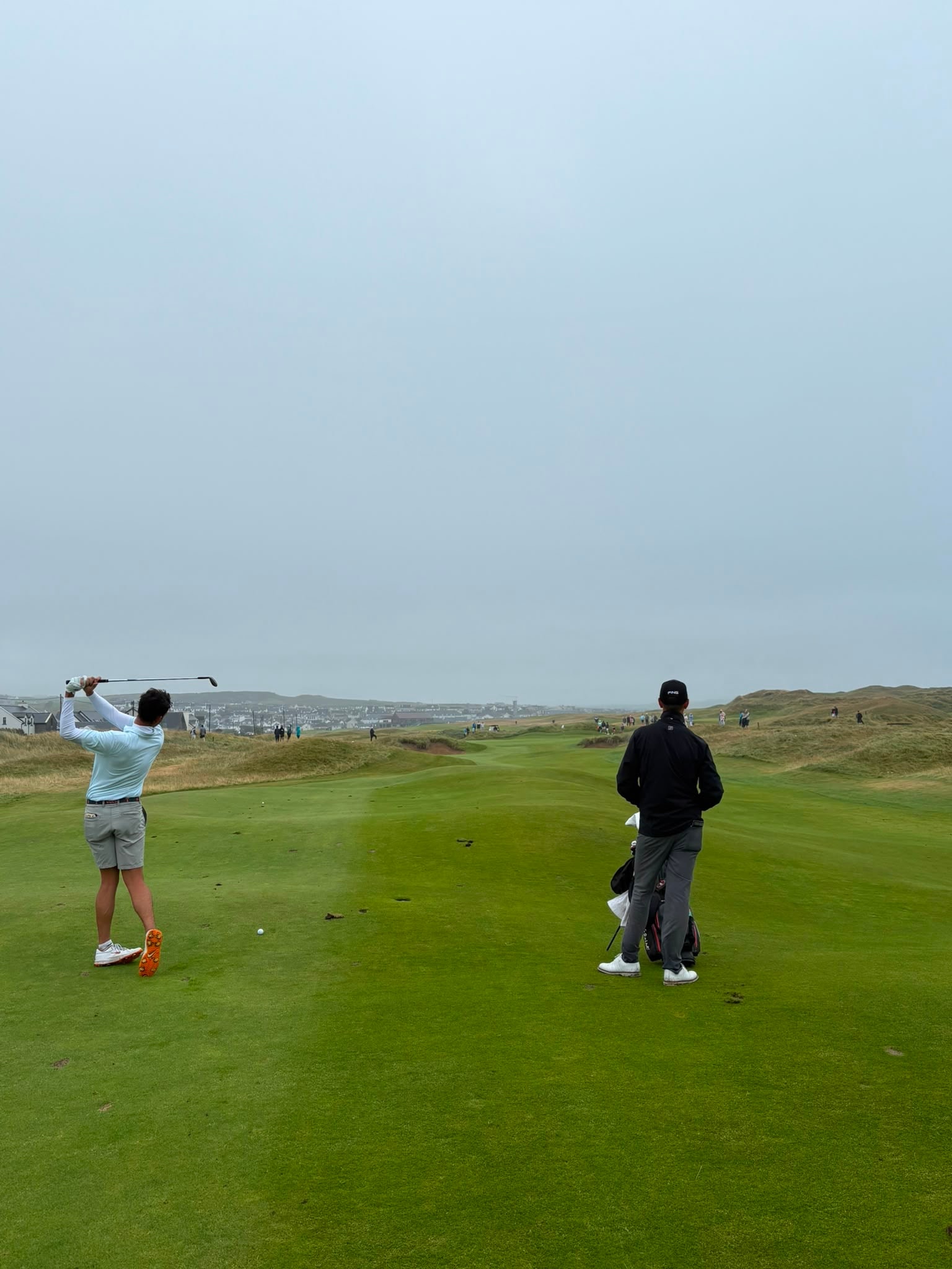 A tee box at Lahinch Golf Club with the Atlantic coastline and blue sky stretching behind