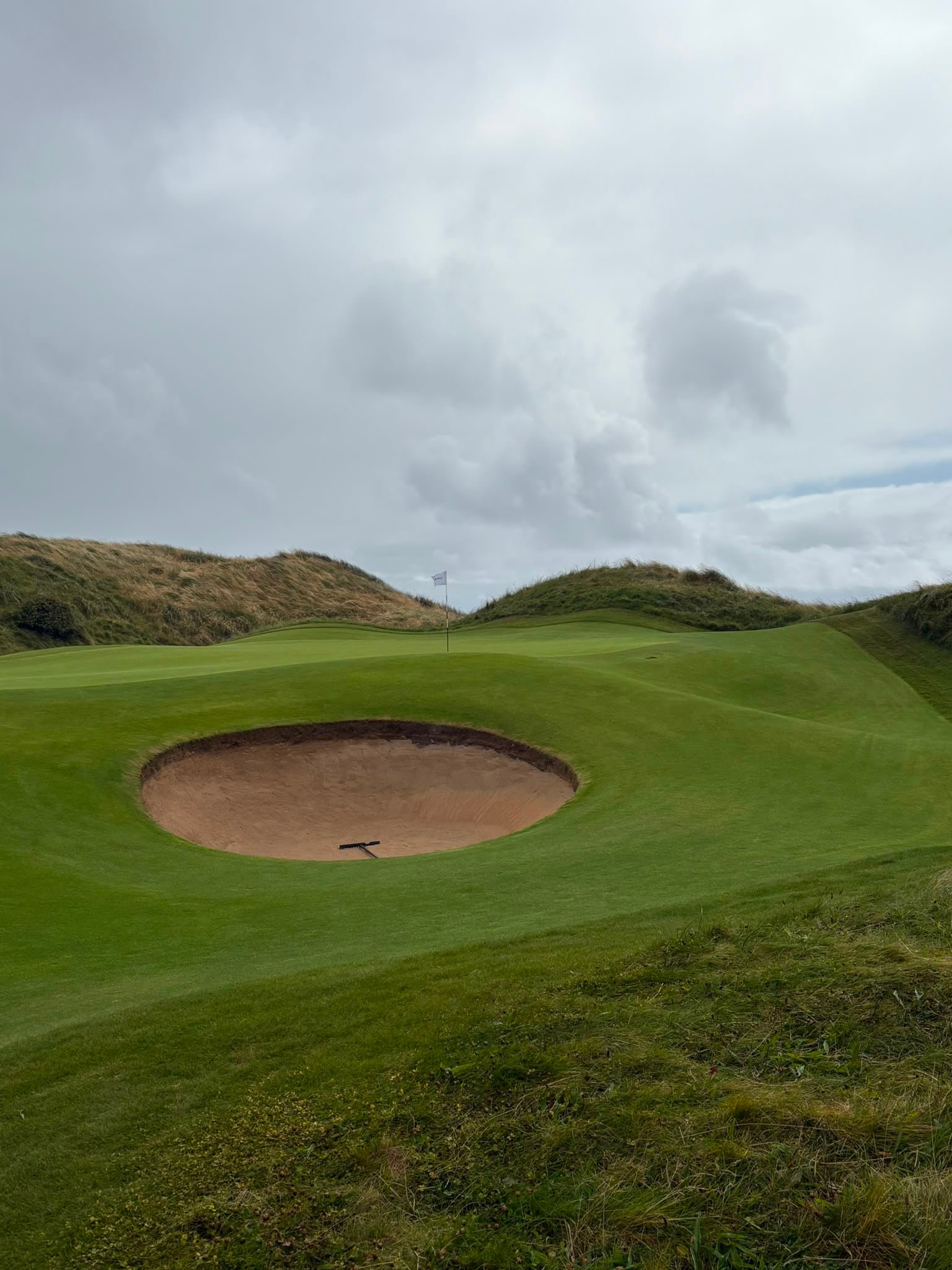 A competitor plays a shot watched by his caddie during the South of Ireland Championship at Lahinch