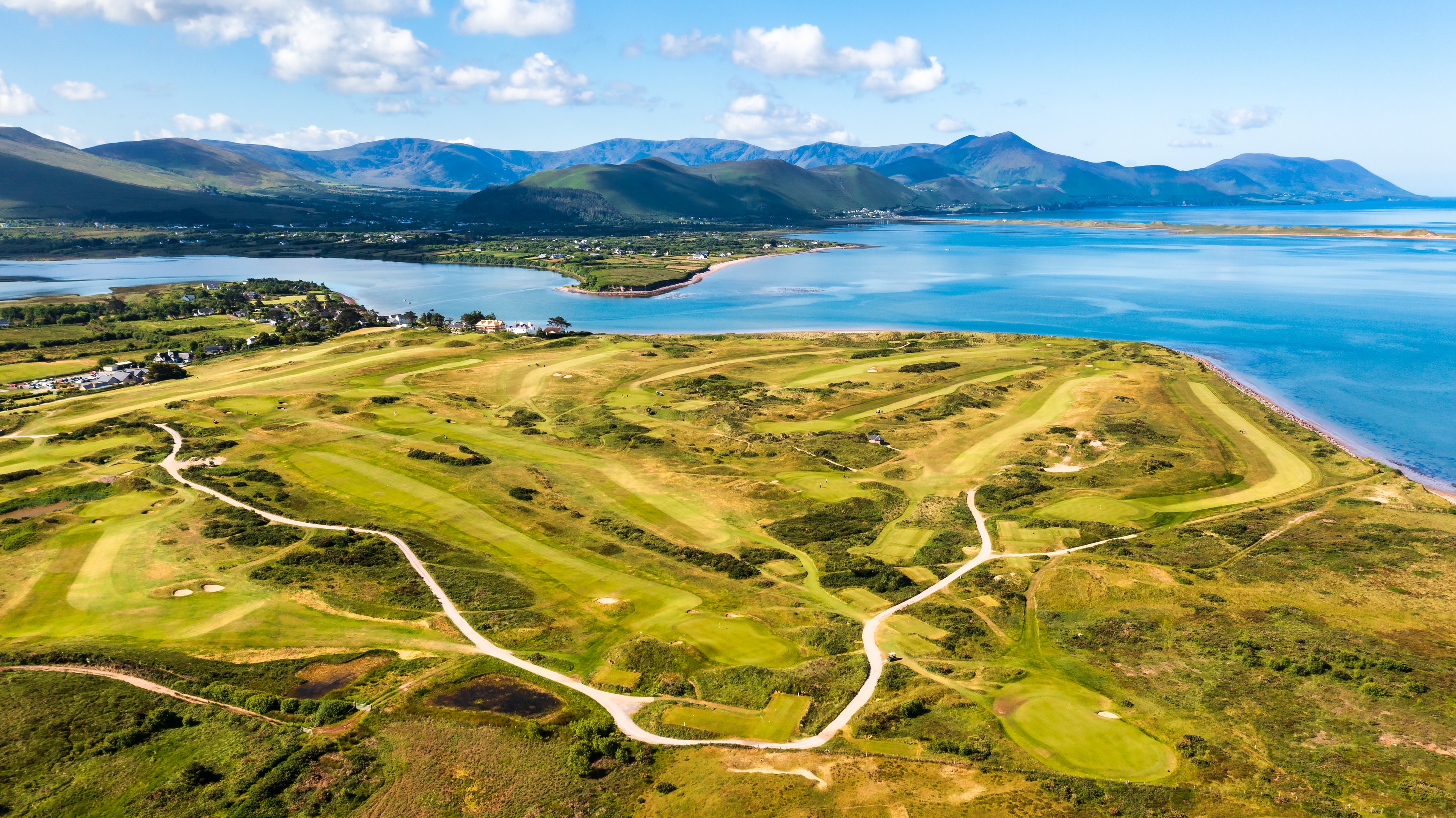 Aerial view of Dooks Golf Club with Dingle Bay and the MacGillycuddy's Reeks beyond